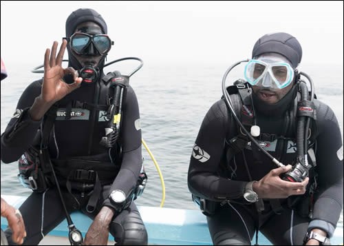 Two divers from the program prepare to enter the water.
