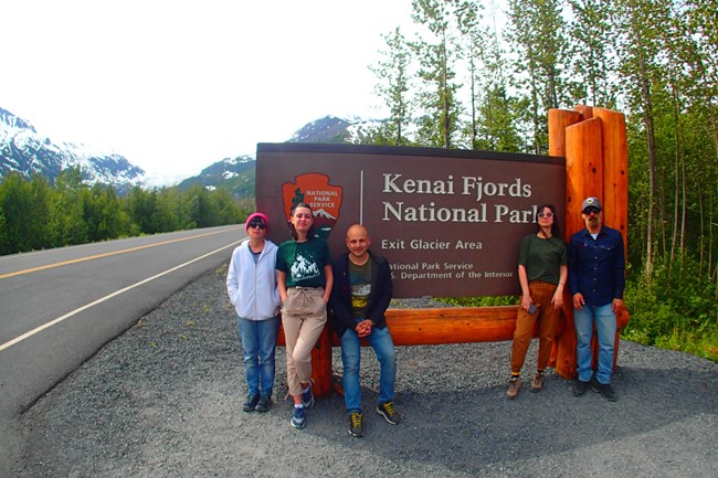 Members of the Georgian delegation pose in front of a park entrance sign.