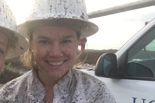 Woman in white hard hat and white clothes.