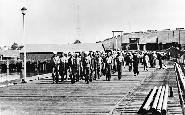 Large group of sailors walking along waterfront