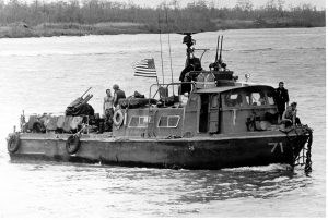 Black and white photo of a 50-foot patrol boat flying an American flag on the water.