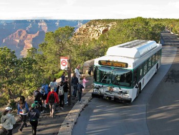 People boarding a shuttle bus on the rim of the Grand Canyon.
