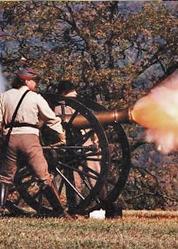 Costumed actors as Civil War soldiers fire the cannon during a battle reenactment
