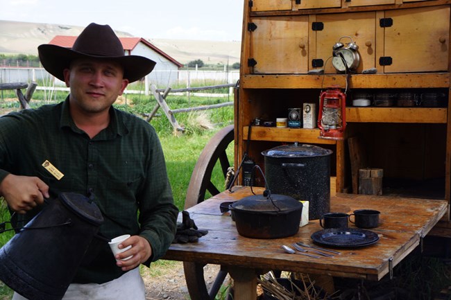 Ranger in historic dress pours coffee during Chuckwagon program