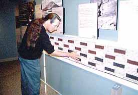 A man touches a wall of beads that represent people lost on the Trail of Tears.