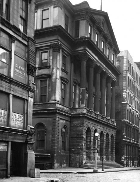Black and white photo of a multistory 19th century office building with large columns