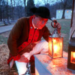 reenactor lighting candle in lantern