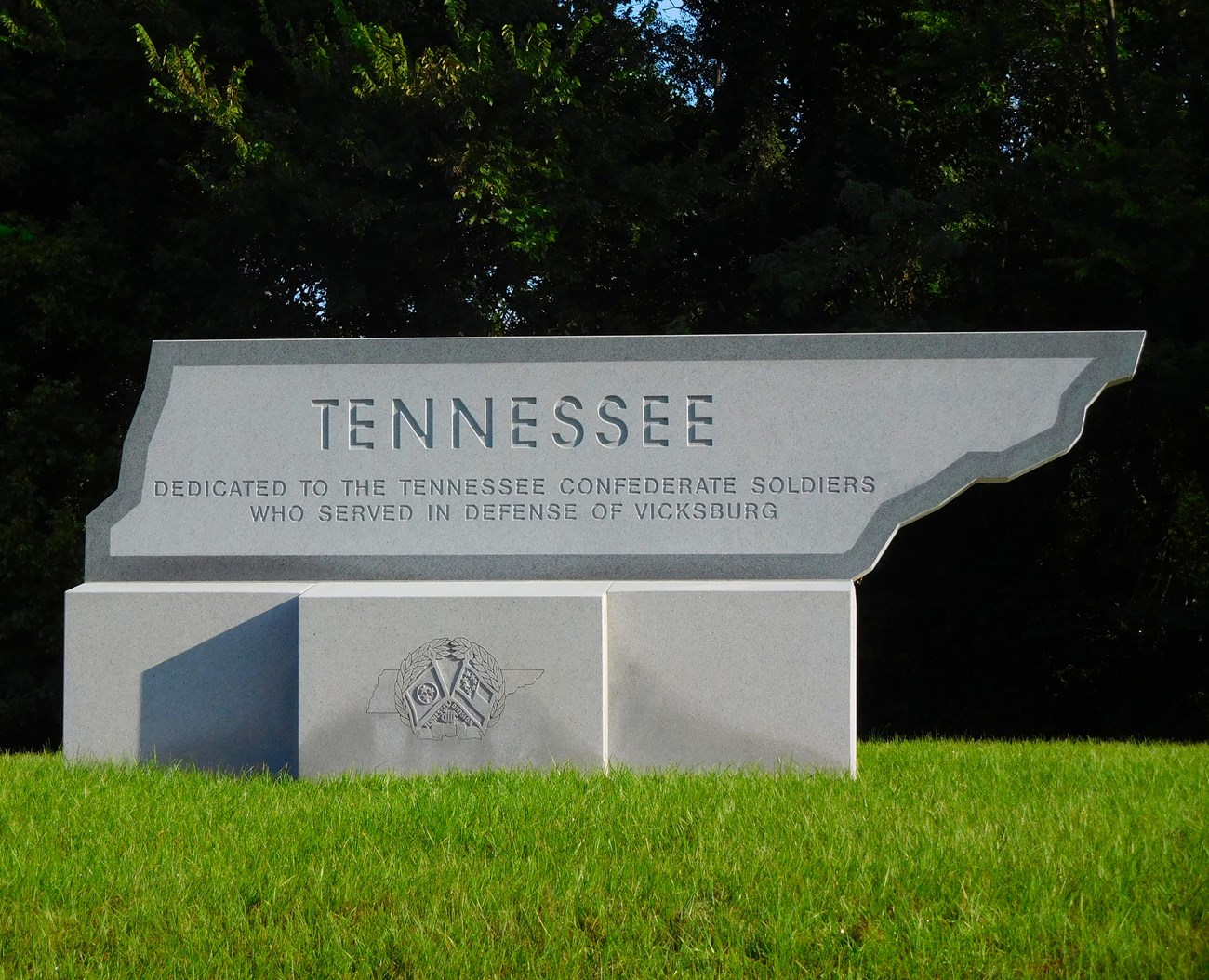 A granite memorial in the shape of the state of Tennessee In the middle of the inscription.