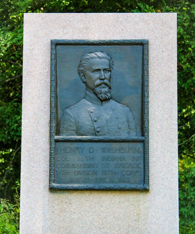 A bronze relief sculpture of a man dressed in uniform