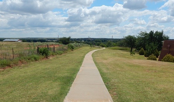 Paved trail going through open field