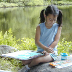 A child paints by the pond at Weir Farm NHS.