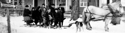 A Young family sleigh ride in front of the house.