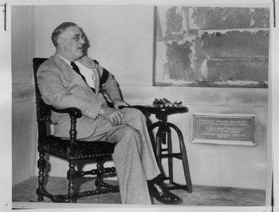 Franklin Roosevelt seated in a chair.