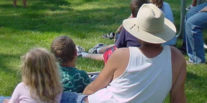 A family sitting on the grass.