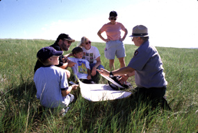 Ranger Reading a Map with a Family of Visitors