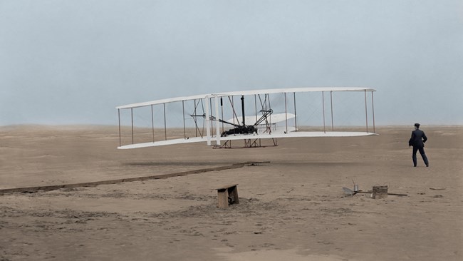 Early bi-plane lifting off the sand