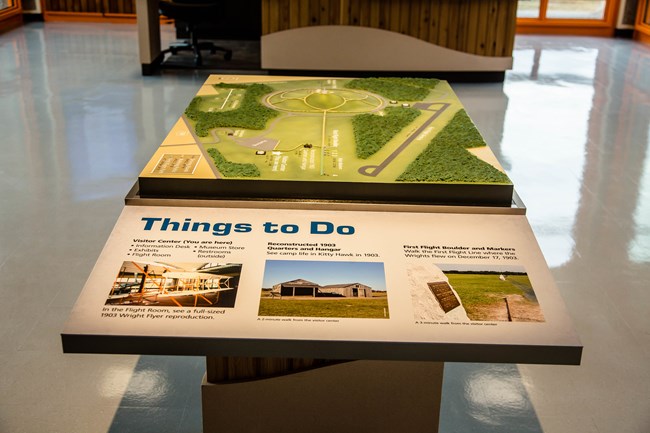 A tactile map of Wright Brothers National Memorial sits in the middle of a visitor center lobby
