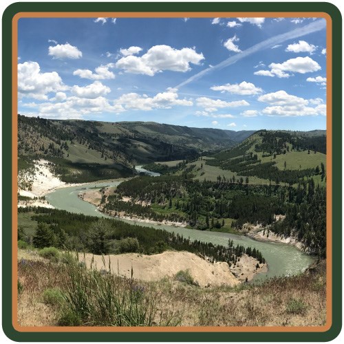 Yellowstone River, a greenish-blue, winds through a valley.