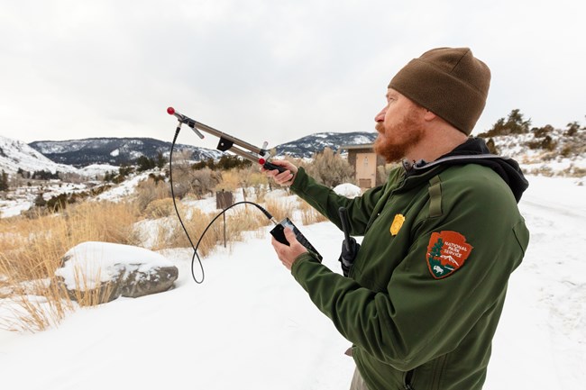 man holds up radio antenna