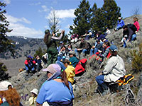 A park ranger works with a group of students on a Yellowstone hillside.