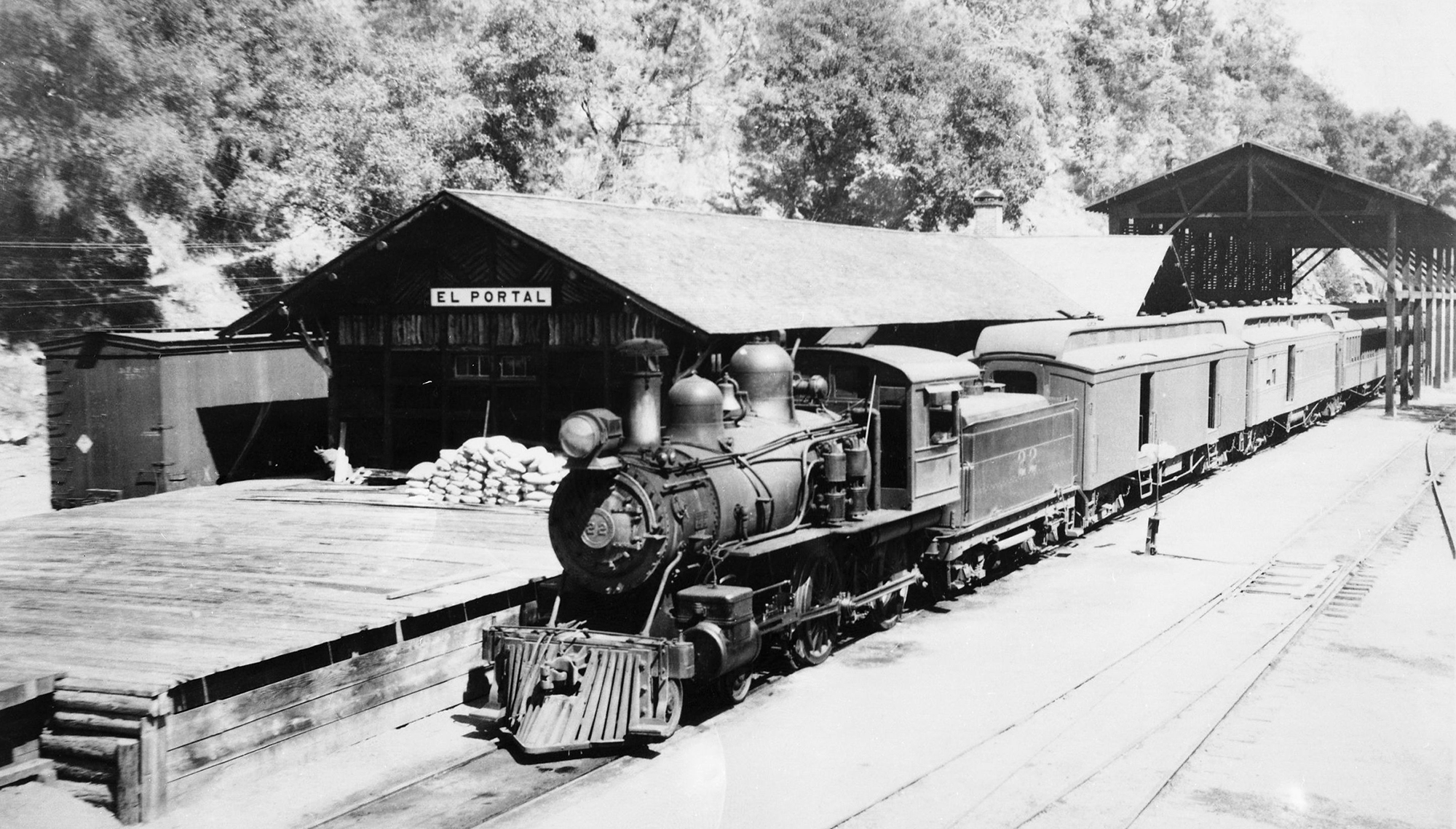 A black and white photo of a steam locomotive at the El Portal train station