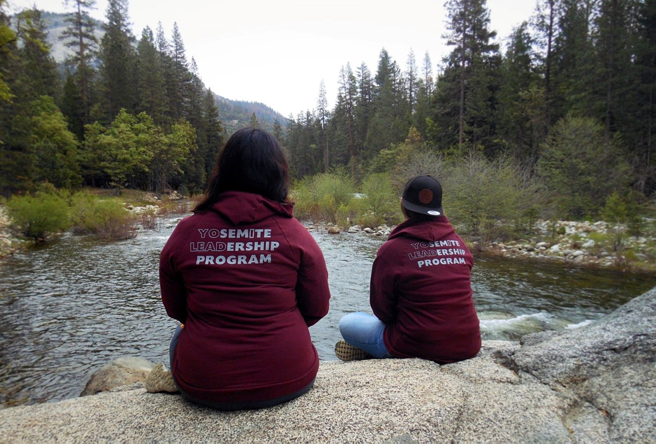 Jennifer and Rachel sitting by river after settling into housing