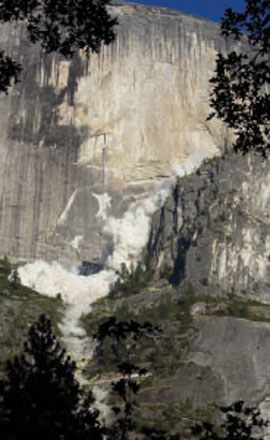 Debris from a rockfall billows in the air