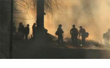 Firefighters and smoke backlit by light