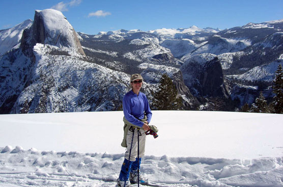 Cross-country skier near Glacier Point; Half Dome and Nevada Fall in background