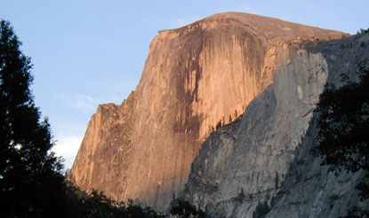 Sheer face of Half Dome, glowing orange from sunset