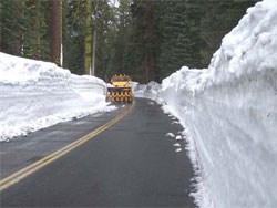 Plow clearing the Tioga Road; snowbanks on both sides of road