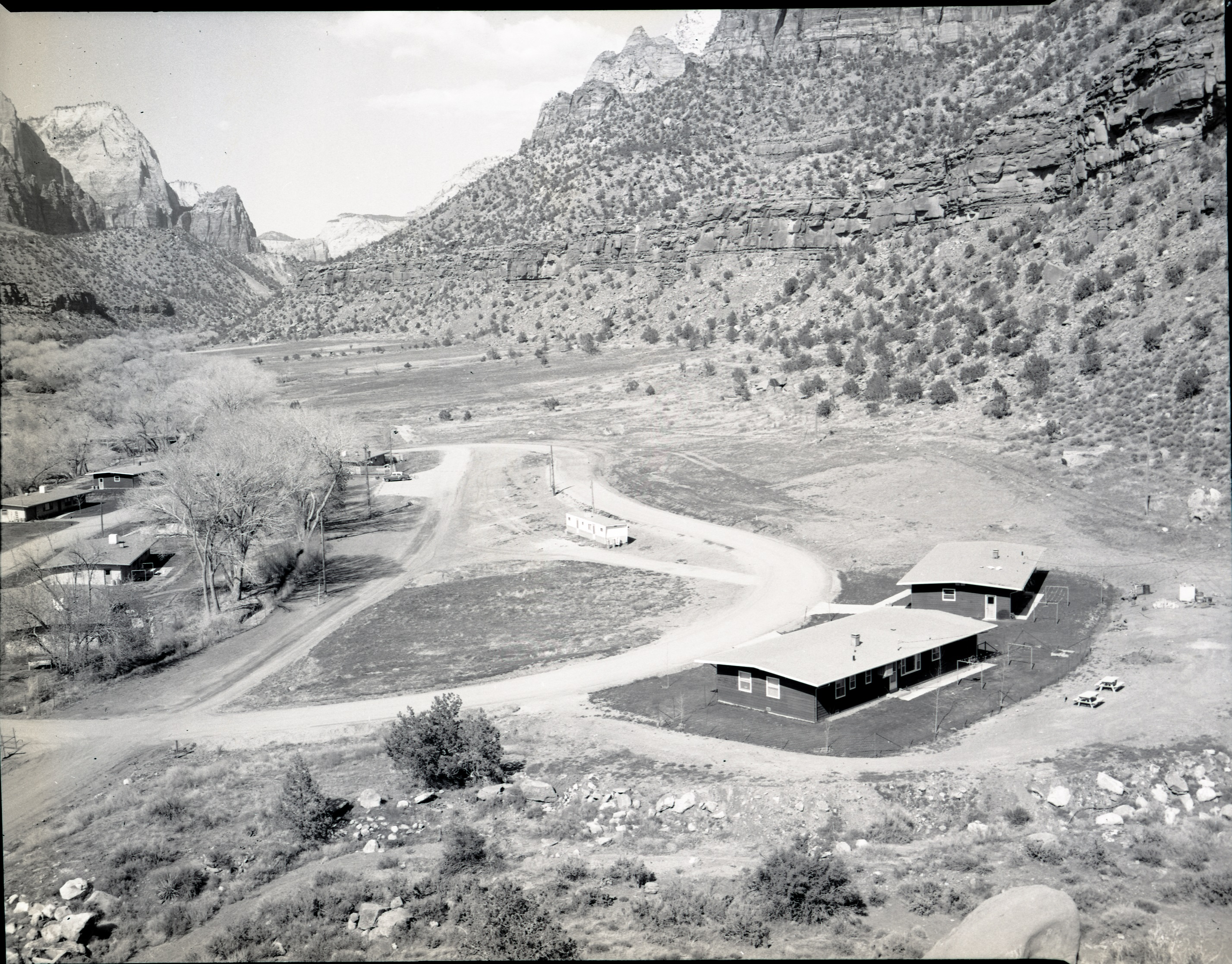 ZION 7832: After the end of the CCC program, the area where Camp NP-4 stood was leveled and turned into the Watchman residential area for National Park Service staff, pictured in this 1966 photo.