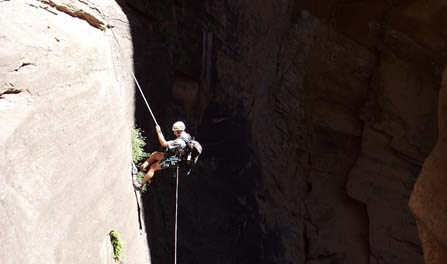 A canyoneer rappelling