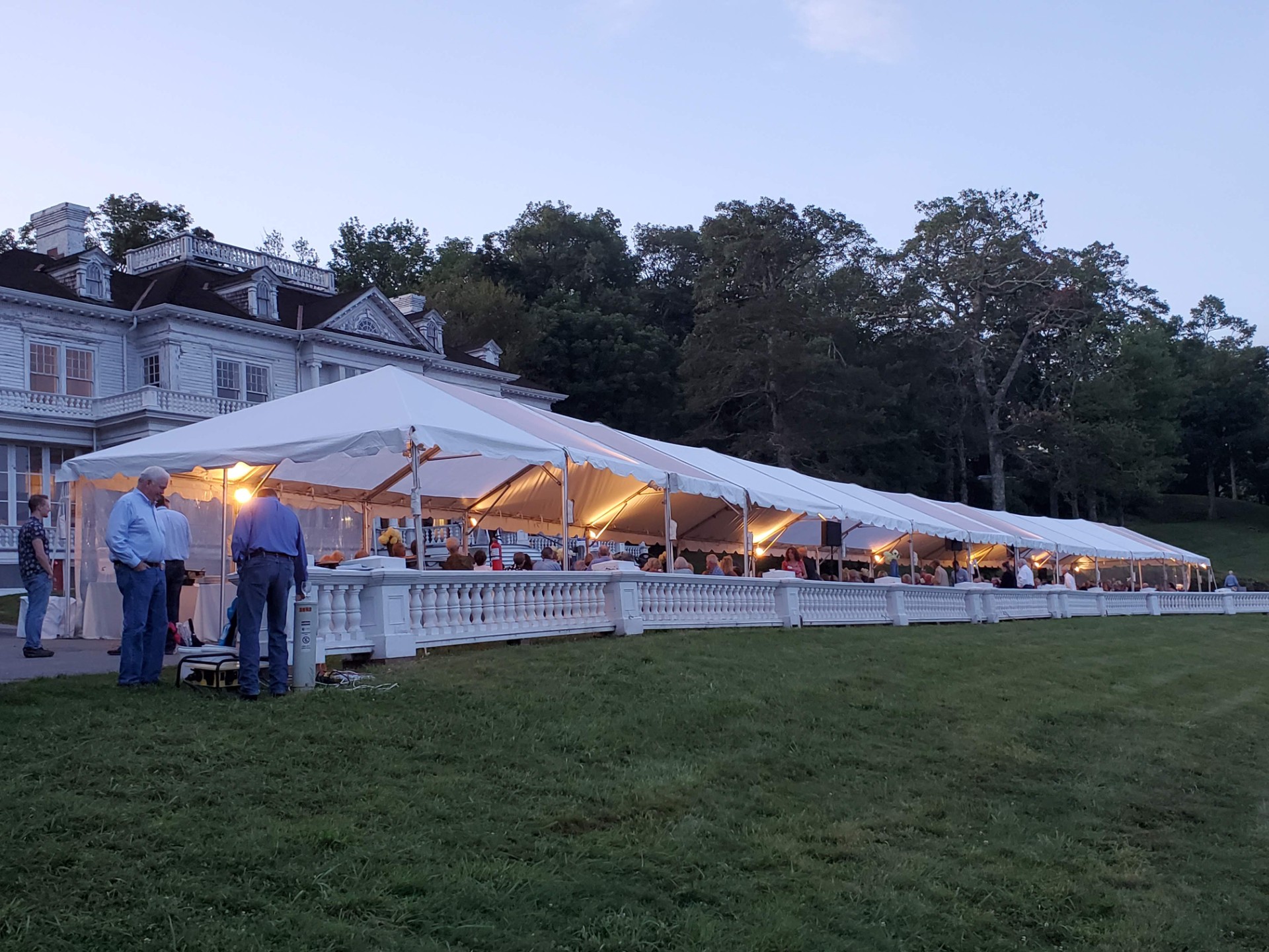 Large event tent in front of a historic building at night