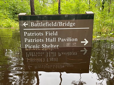 Flood waters cover the lower portion of a park sign.