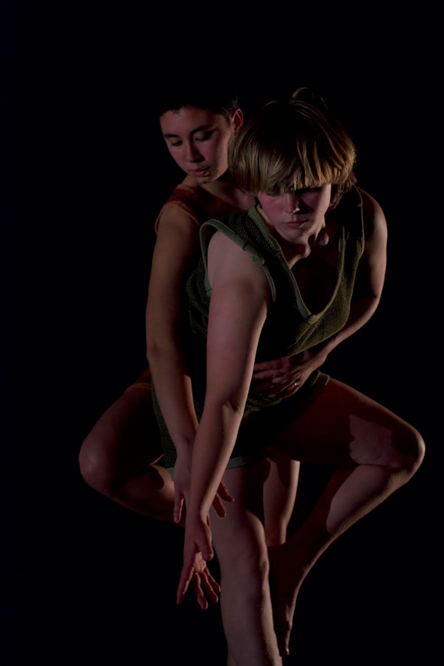 Two dancers in dramatic lighting