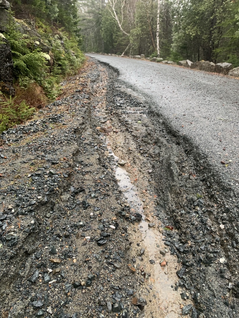 A washout on the left side of a stone road.