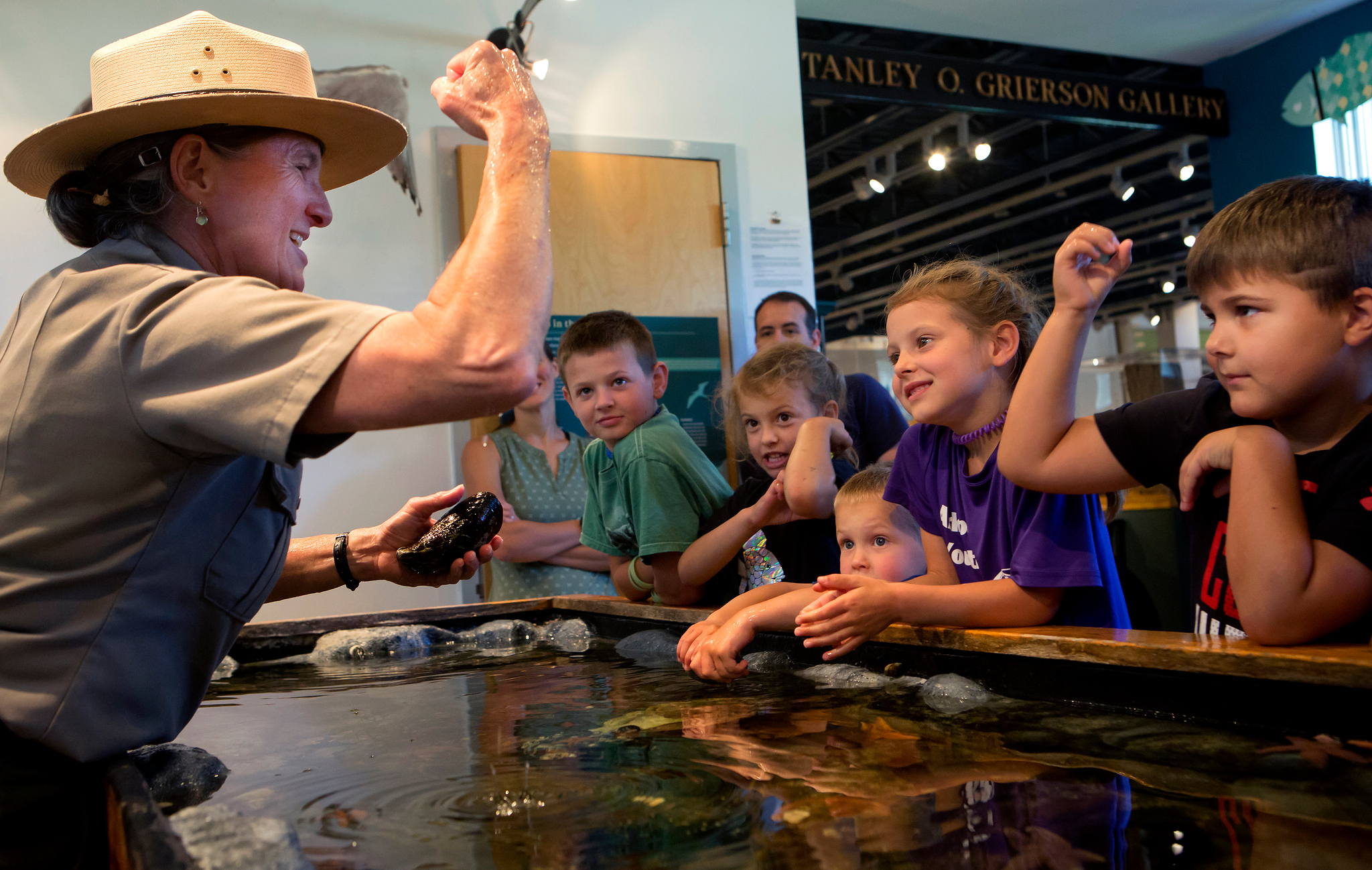 Ranger and children around touch tank