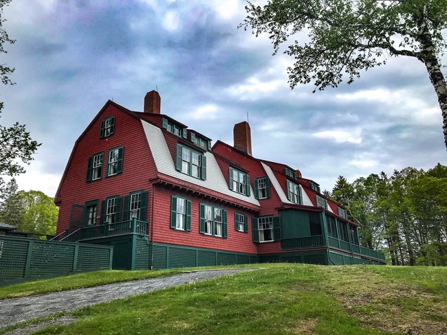 Red historic building on a green hillside