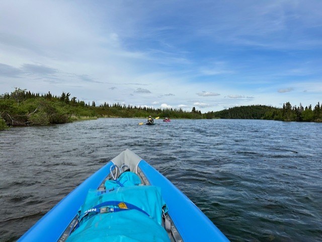 View from a blue pack raft looking down river on a paddle trip