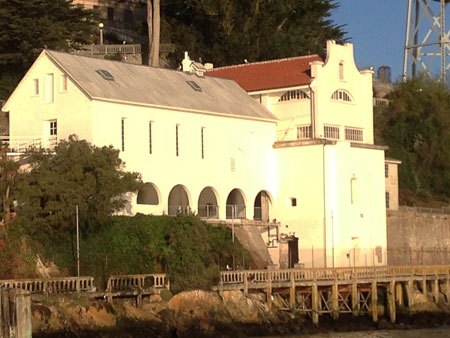 large white building clustered on hill over water