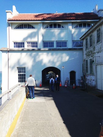 people walking through tall white building with red roof