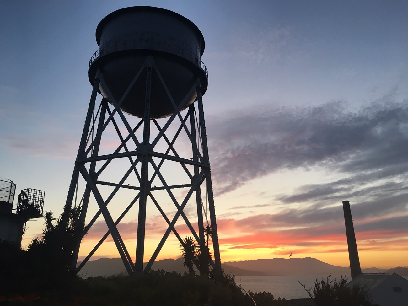 The Alcatraz water tower silhouetted against the sunset.