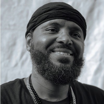 Black man with beard smiles at camera