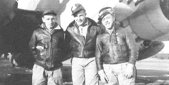 Three men in front of a plane