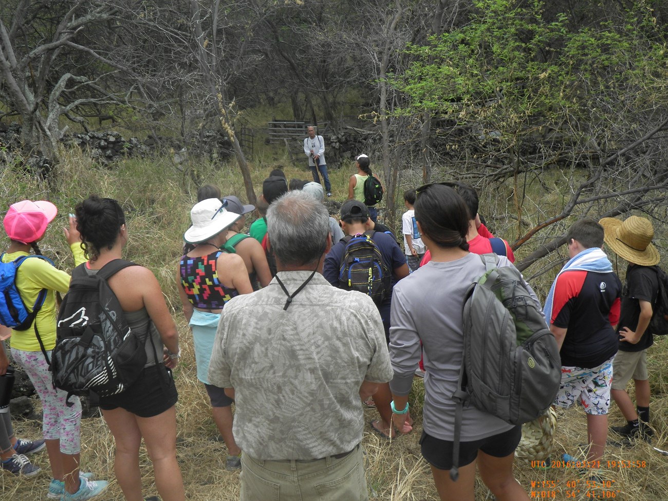 Group of hikers standing at trailhead while leader speaks