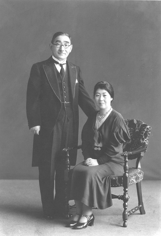 A woman sitting in a chair and a man standing next to her