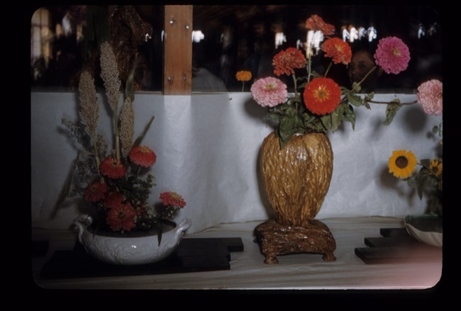 Two sets of flowers vases, a white ceramic bowl on the left and a wooden vase to the right