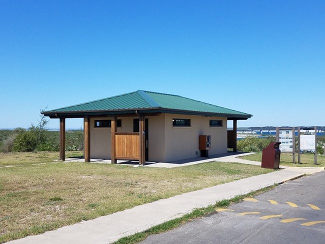 Square, freshly painted building with view of lake behind.
