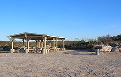 Rock Quarry Group Campsite's picnic tables under large ramada with grill.